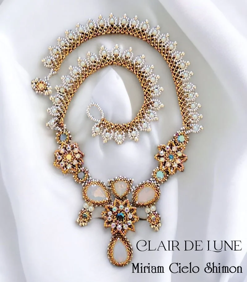 A luxurious set of jewelry including a necklace, earrings, and a ring, all decorated with pearls, gold beads, and intricate floral designs, displayed on a white fabric background.