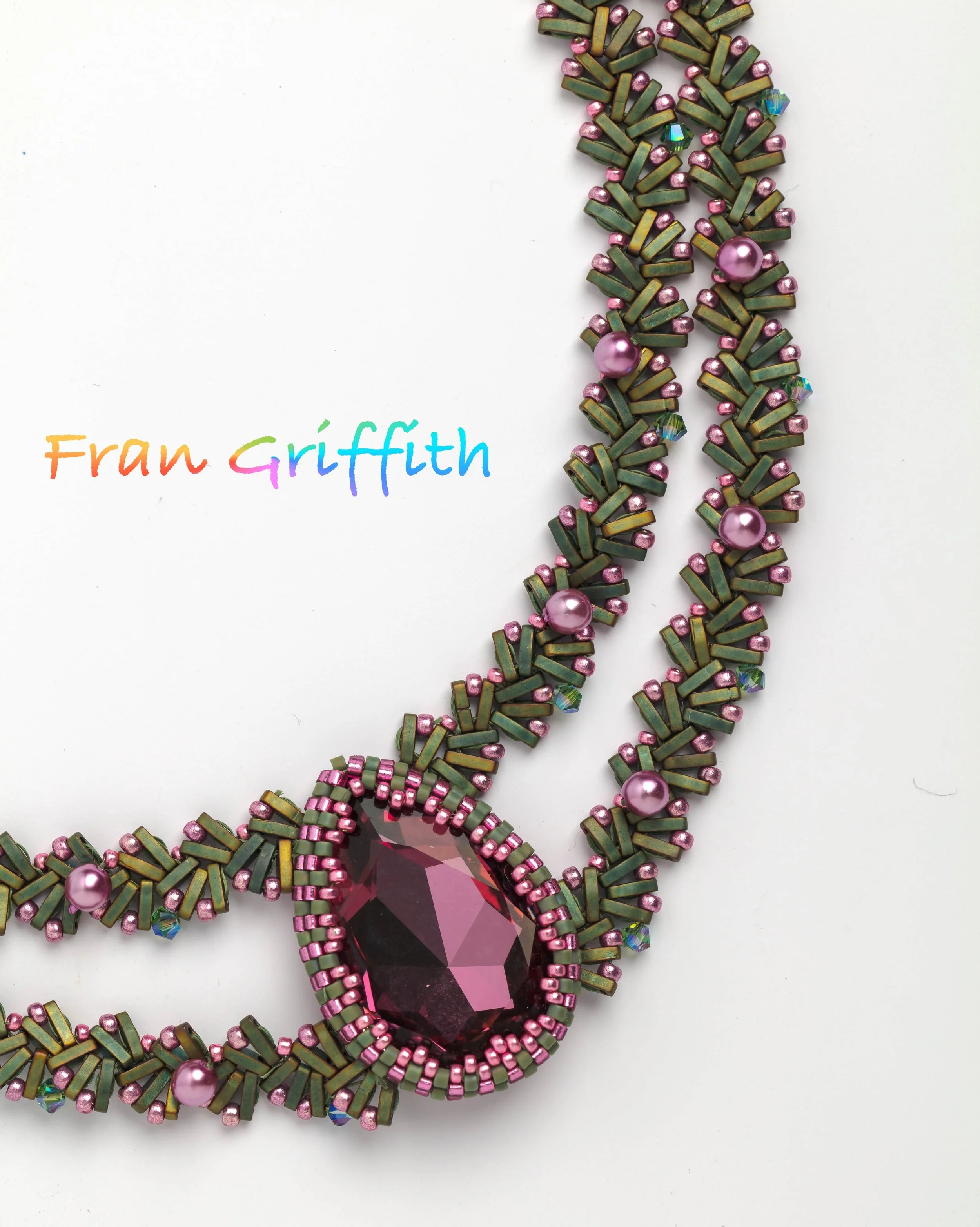 Close-up of a decorative pink and green beaded jewelry piece with a large purple gemstone at the center, placed on a white background. The image features colorful, handwritten text in the lower left corner that reads 'Fran Griffith.'
