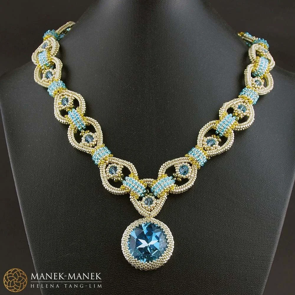 A detailed beaded necklace with blue and white beads, featuring a large round blue gemstone pendant.