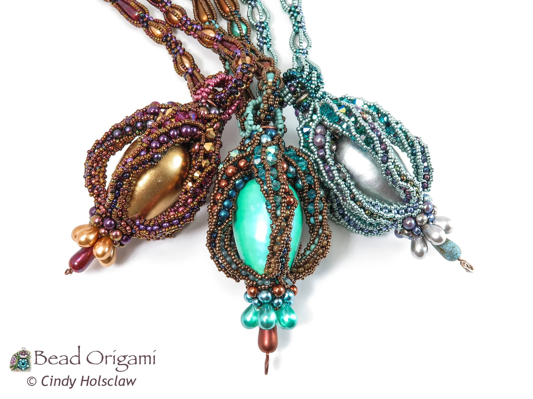 A collection of colorful beaded necklaces with various sizes and shapes, some featuring large pendants, arranged overlapping on a white background.