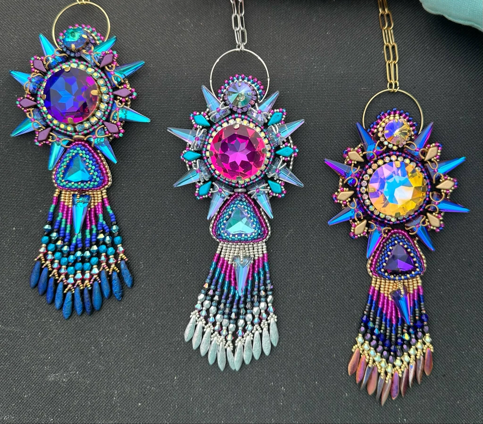 Colorful beaded jewelry including necklaces and earrings displayed on a black surface.