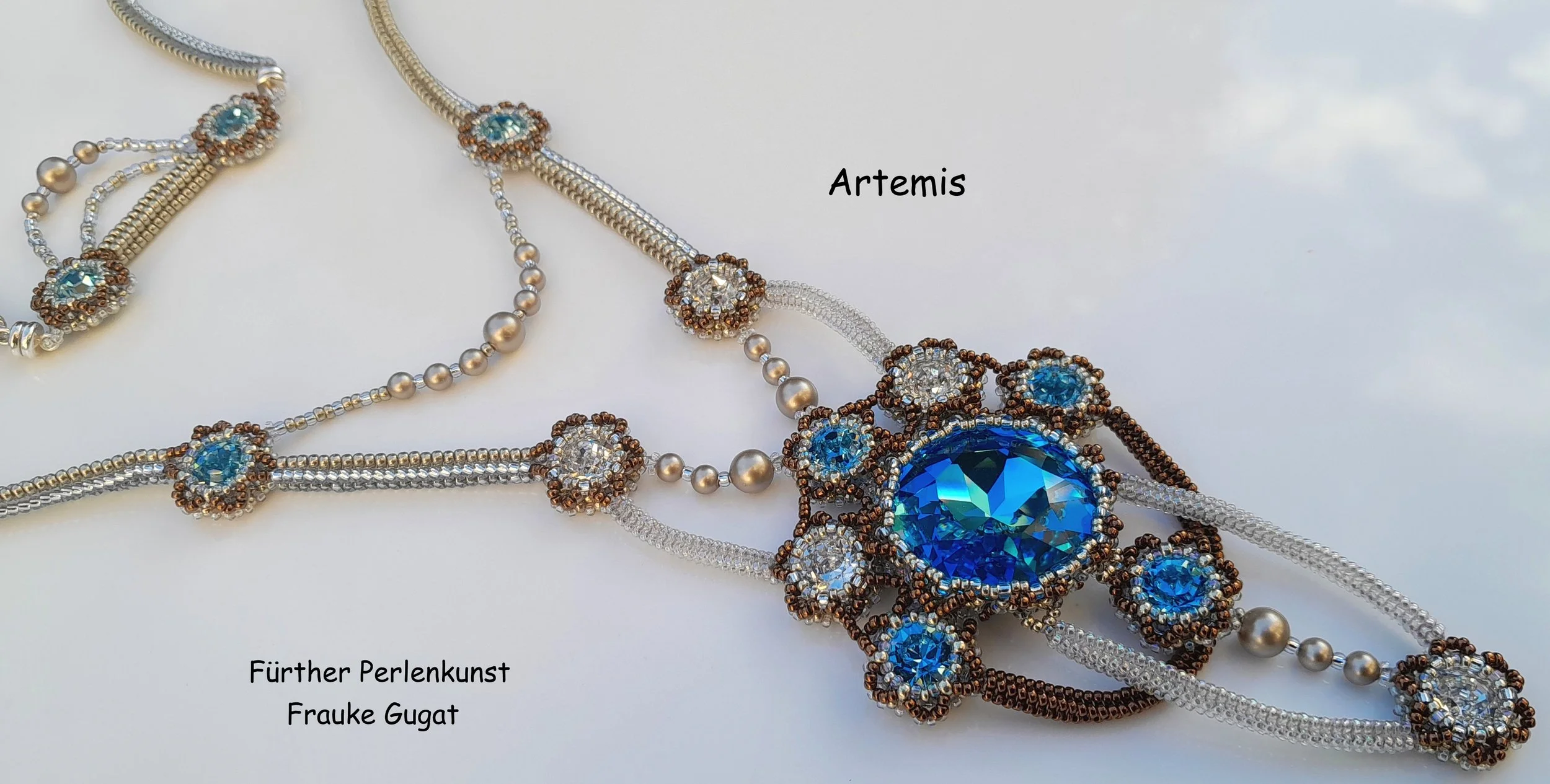 Close-up of intricate jewelry, including necklaces with blue and clear gemstones, pearls, and detailed beadwork on a white background. The image is labeled with the words 'Artemis', 'Fürther Perlenkunst', and 'Frauke Gugat'.