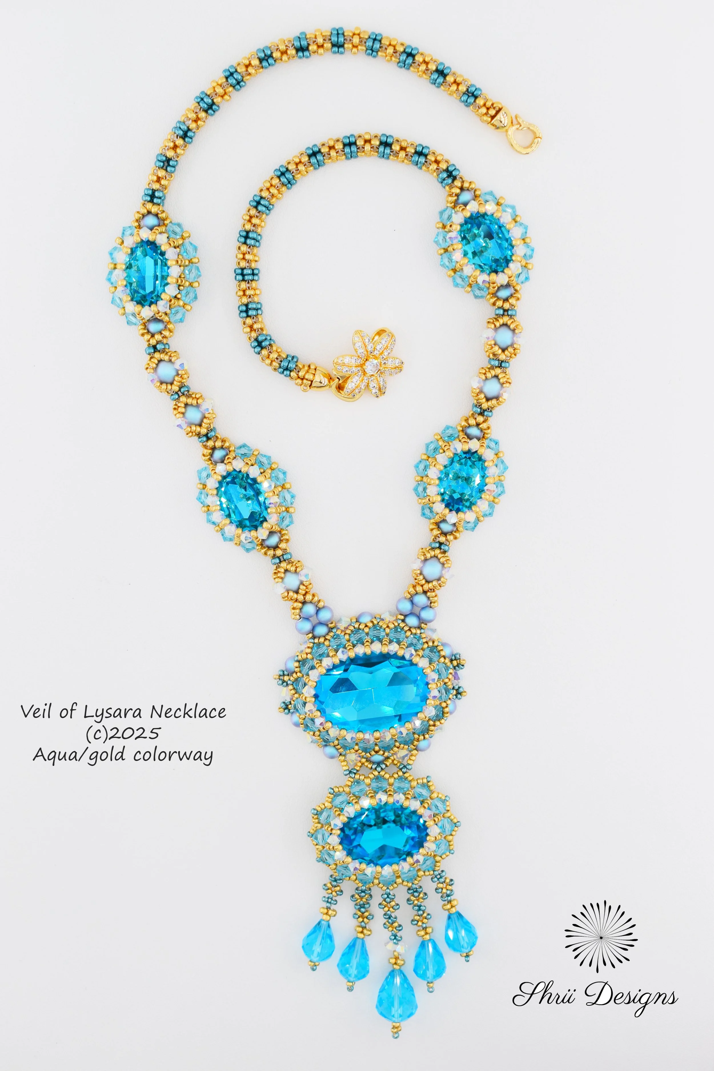 A detailed blue and gold beaded necklace called Veil of Lysara Neckelage, featuring large blue gemstones and intricate beadwork, with a flower-shaped clasp and dangling blue beads, designed by Shrii Designs.