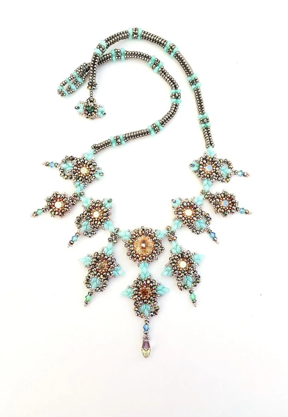 A beaded necklace with floral and leaf motifs, featuring light blue, gold, and dark beads, displayed against a white background.