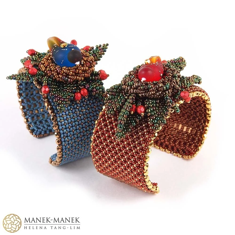 Two beaded bracelets decorated with small colorful beads and larger red and blue beads, designed to resemble stylized Christmas trees.