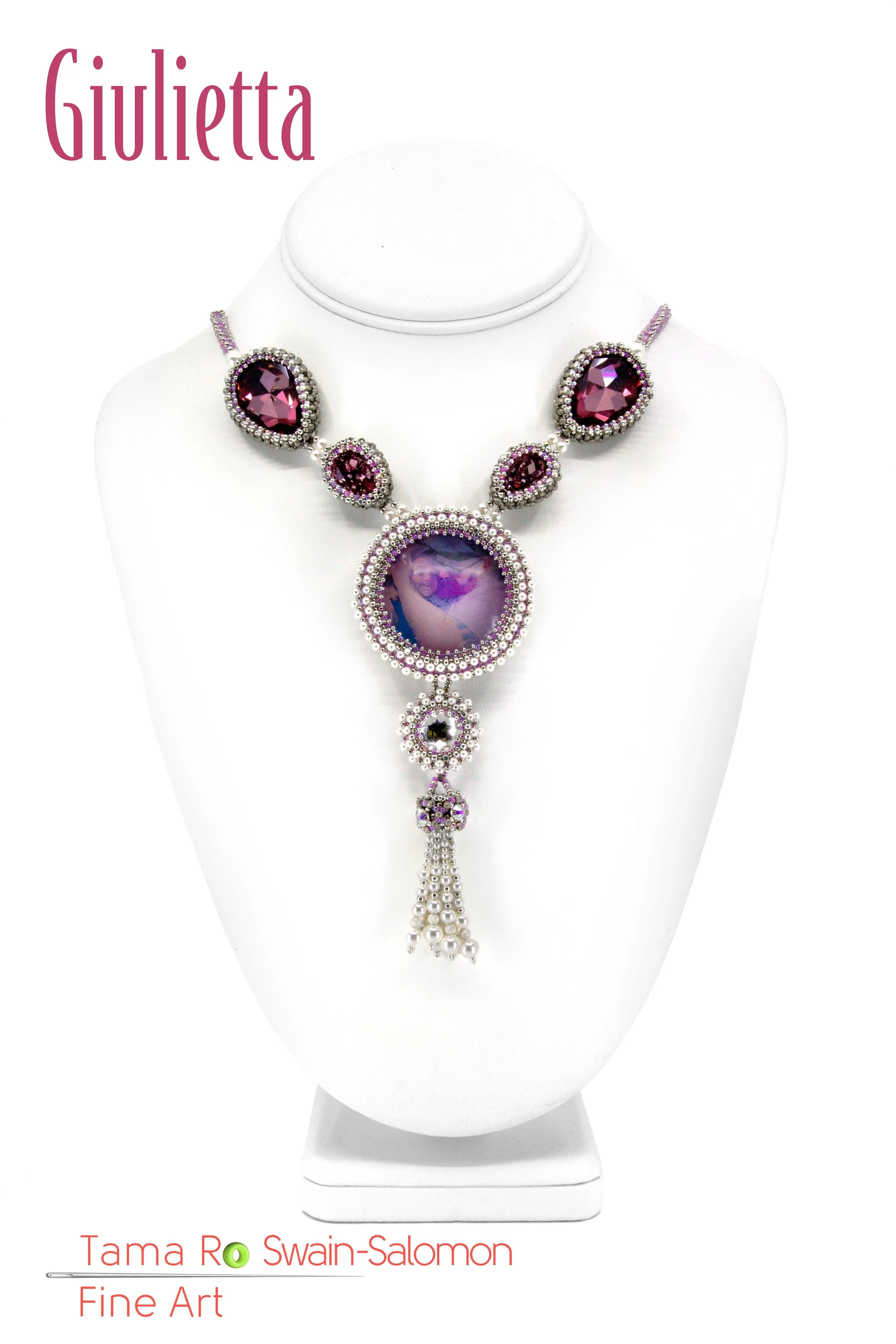 A necklace with large purple and pink gemstones, surrounded by small silver beads, displayed on a white bust form.