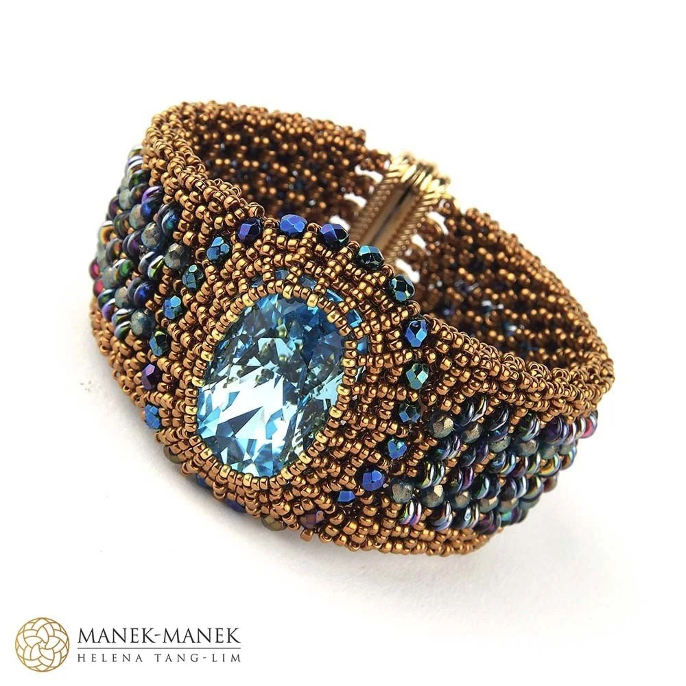 Beaded bracelet with a large central blue gemstone and intricate beading details in bronze and multicolored beads.