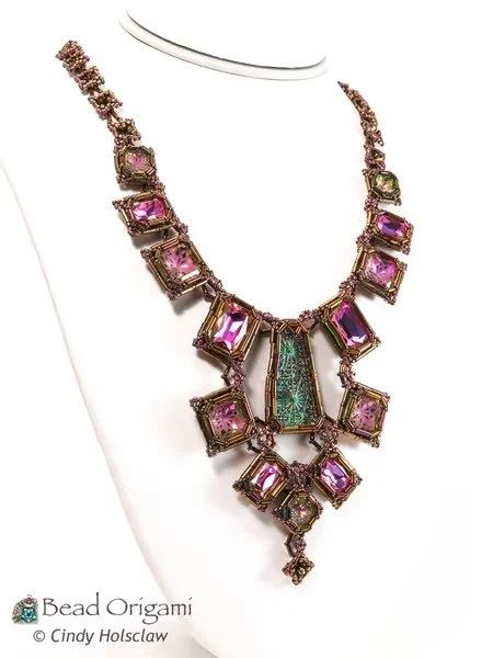 Jewelry necklace with pink and green gemstones on display.