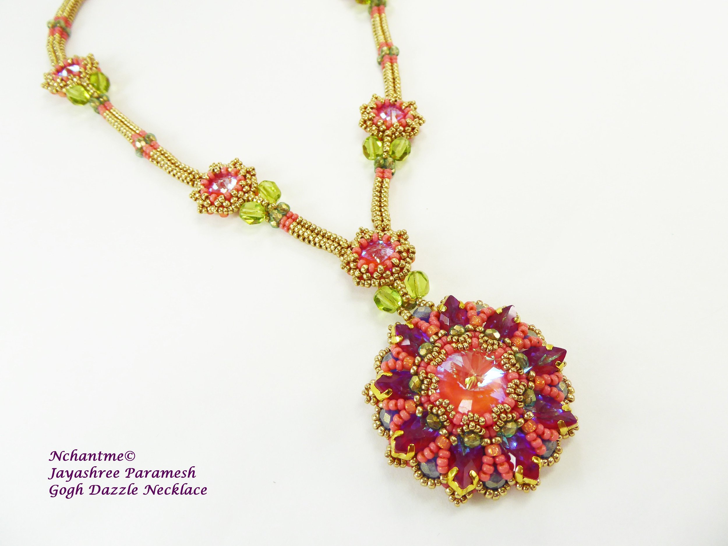 Colorful beaded necklace with pink, green, purple, and gold beads arranged in floral and geometric patterns, featuring large central pink and purple gemstone accents.