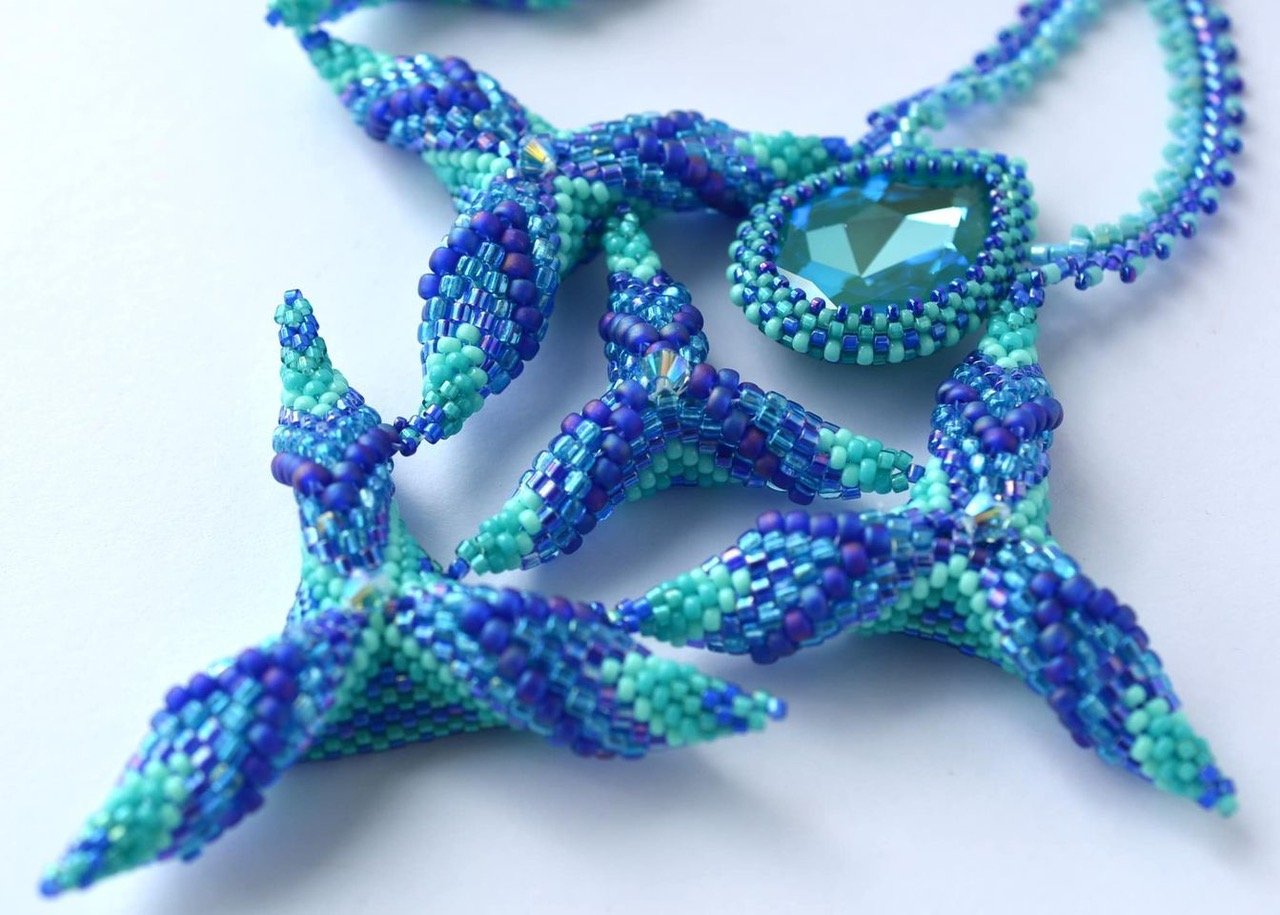 Blue and green beaded starfish-shaped jewelry with a teardrop-shaped gemstone pendant.