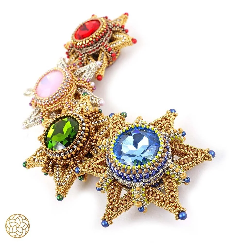 Colorful beaded brooch resembling a lion with large gemstone eyes in red, pink, green, and blue.