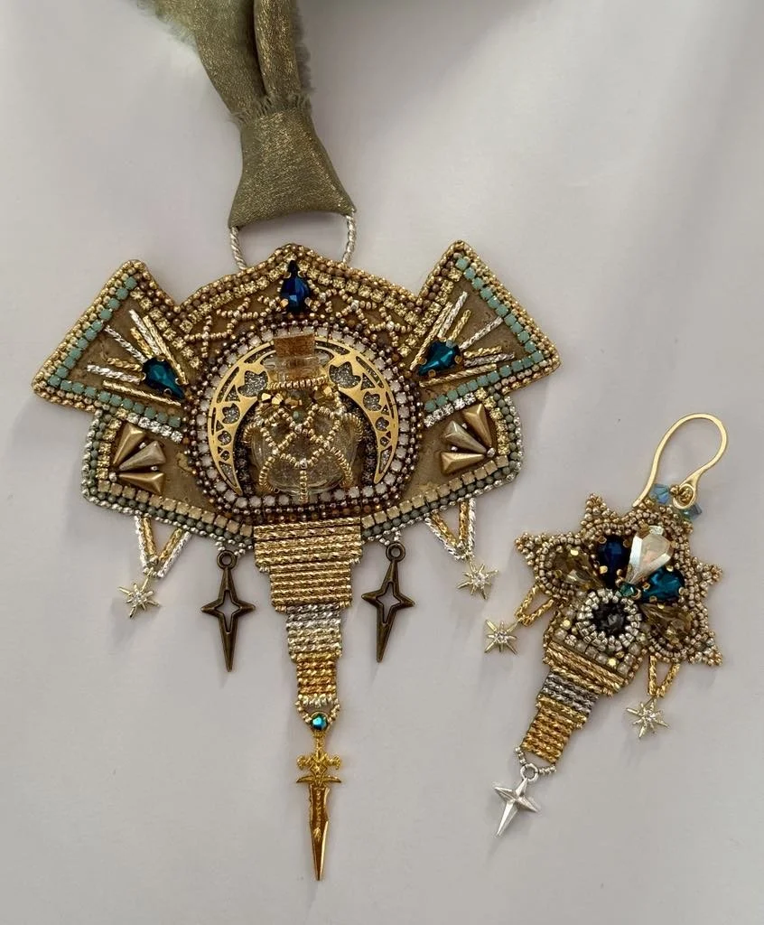 Decorative gold-tone jewelry with blue and clear gemstones, featuring a list and star motifs, including a large pendant and a matching earring.