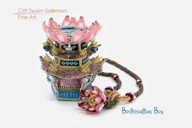 A beaded jewelry sculpture resembling a lotus flower, with a necklace and a box, decorated with intricate beadwork in pink, gold, and blue colors.