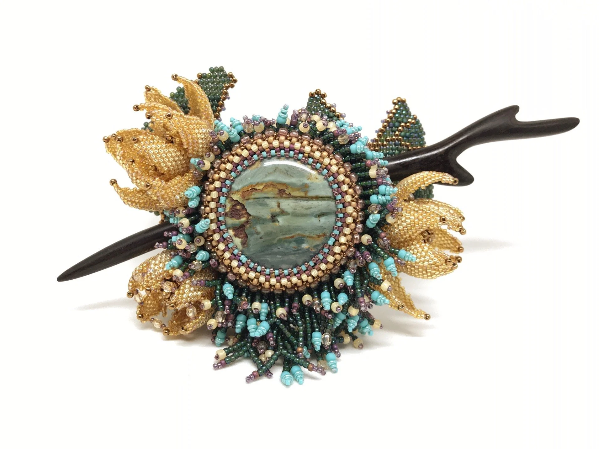 Beaded hair accessory with sunflower design and a central shell ornament.