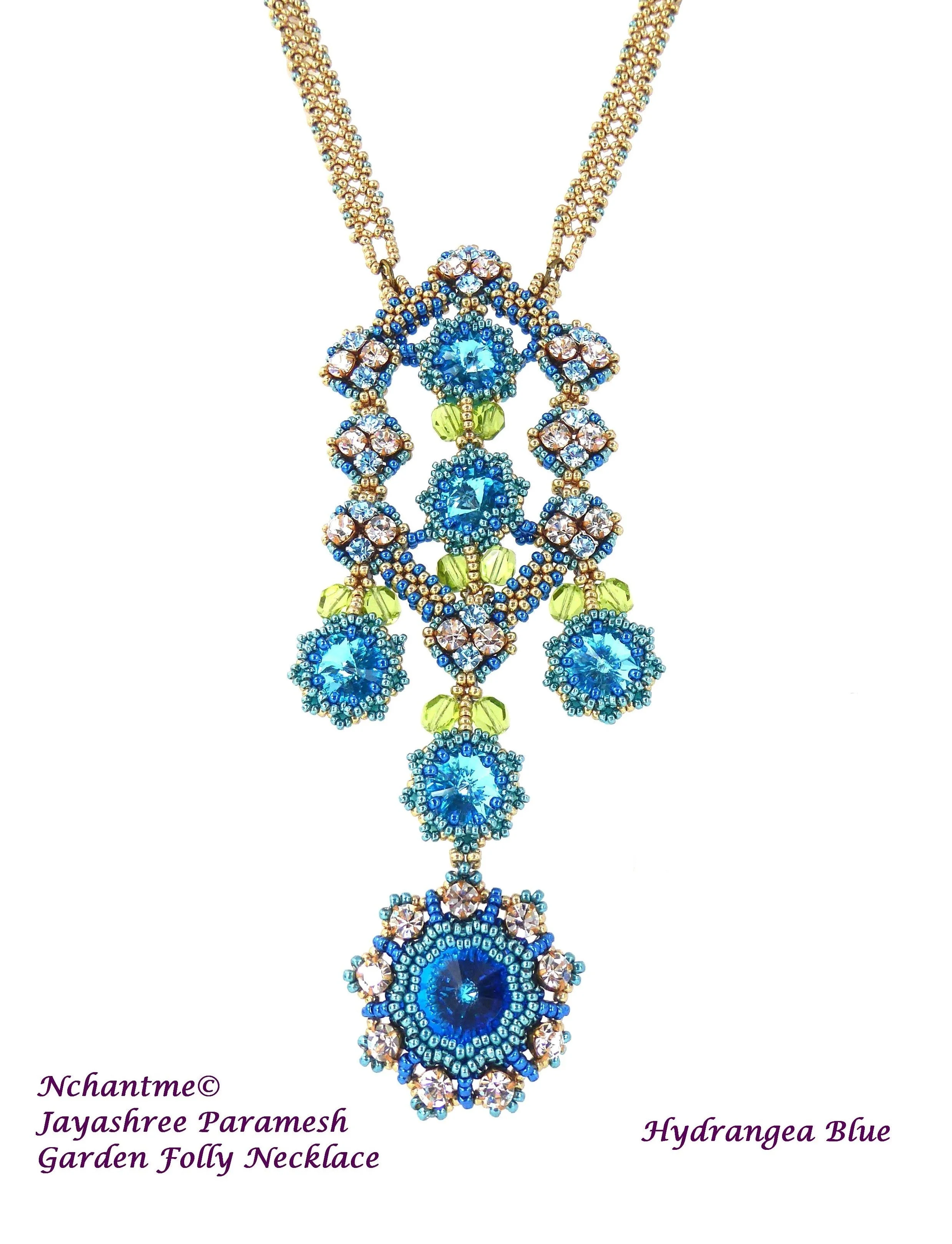 A colorful beaded necklace with blue and gold beads, decorated with multiple aqua blue gemstones, green beads, and pinkish stones, featuring a detailed floral and geometric design, named 'Garden Folly Necklace' in the description.