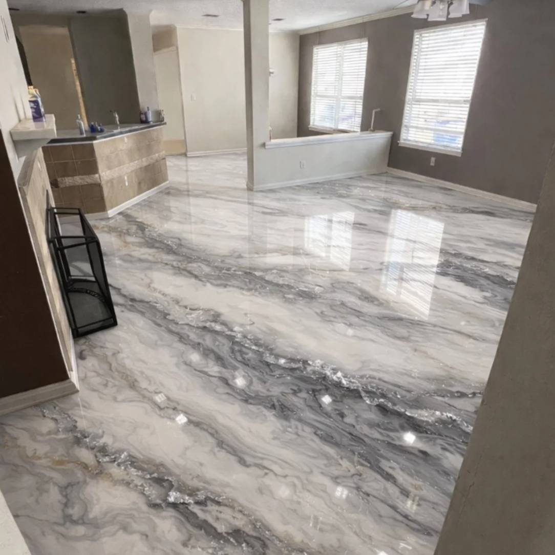 Empty living room with large marbled epoxy floors in white, gray, and black veining, and three windows with blinds.