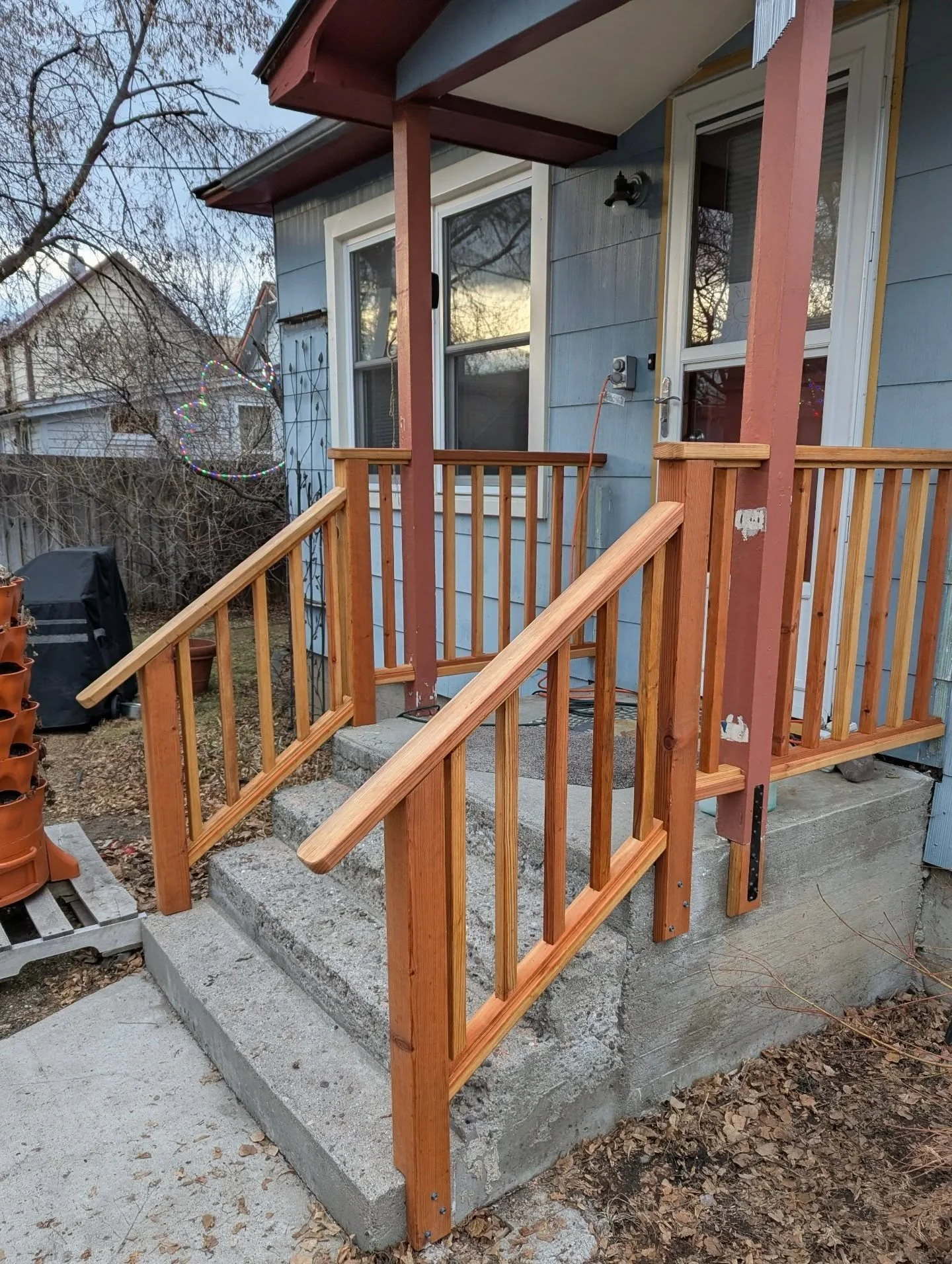 A little back entry handrail upgrade. We used redwood throughout with a cedar toned exterior stain.  The previous carpenter had mismeasured and instead of redoing their work, they just kicked the posts holding the roof in so the bottoms would fall on
