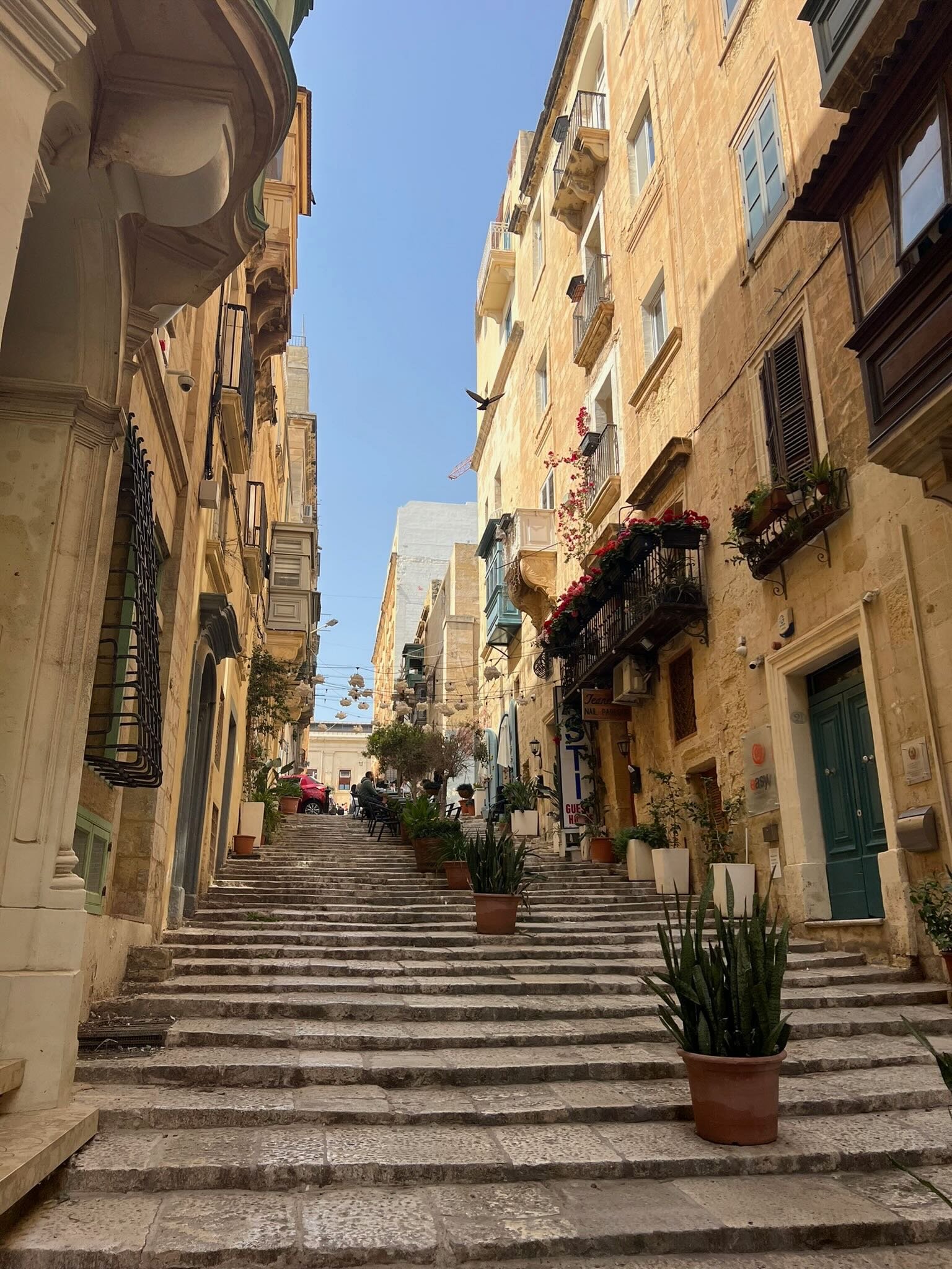 A narrow, stone-paved street with ascending steps in Malta - Travel - KPJ Collective