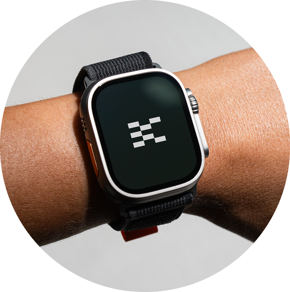 Smartwatch on a person's wrist displaying a geometric pattern of white squares and lines on a black background.