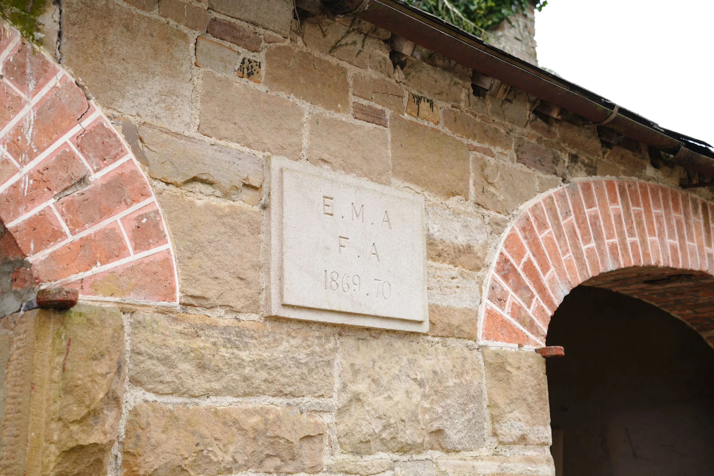 Another stone building on site, plaque displaying 1869 dates