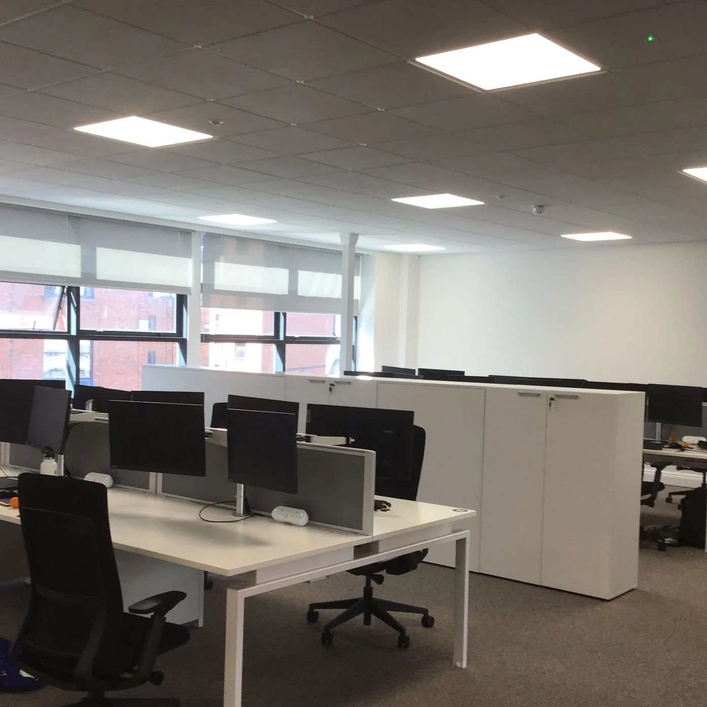 Modern office fit-out with desks, monitors, and partitioned workstations in a commercial workspace