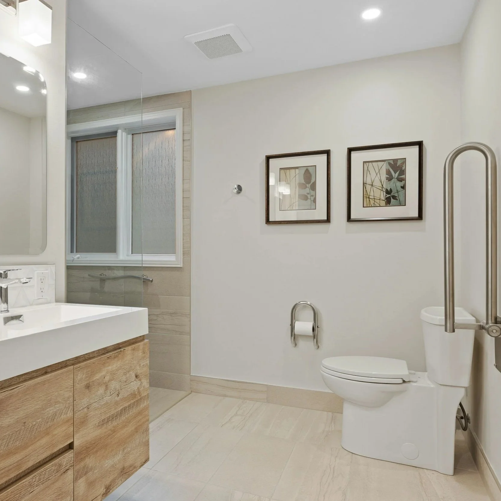 Accessible bathroom fit-out with walk-in shower, grab rails, and wide layout designed for assisted living