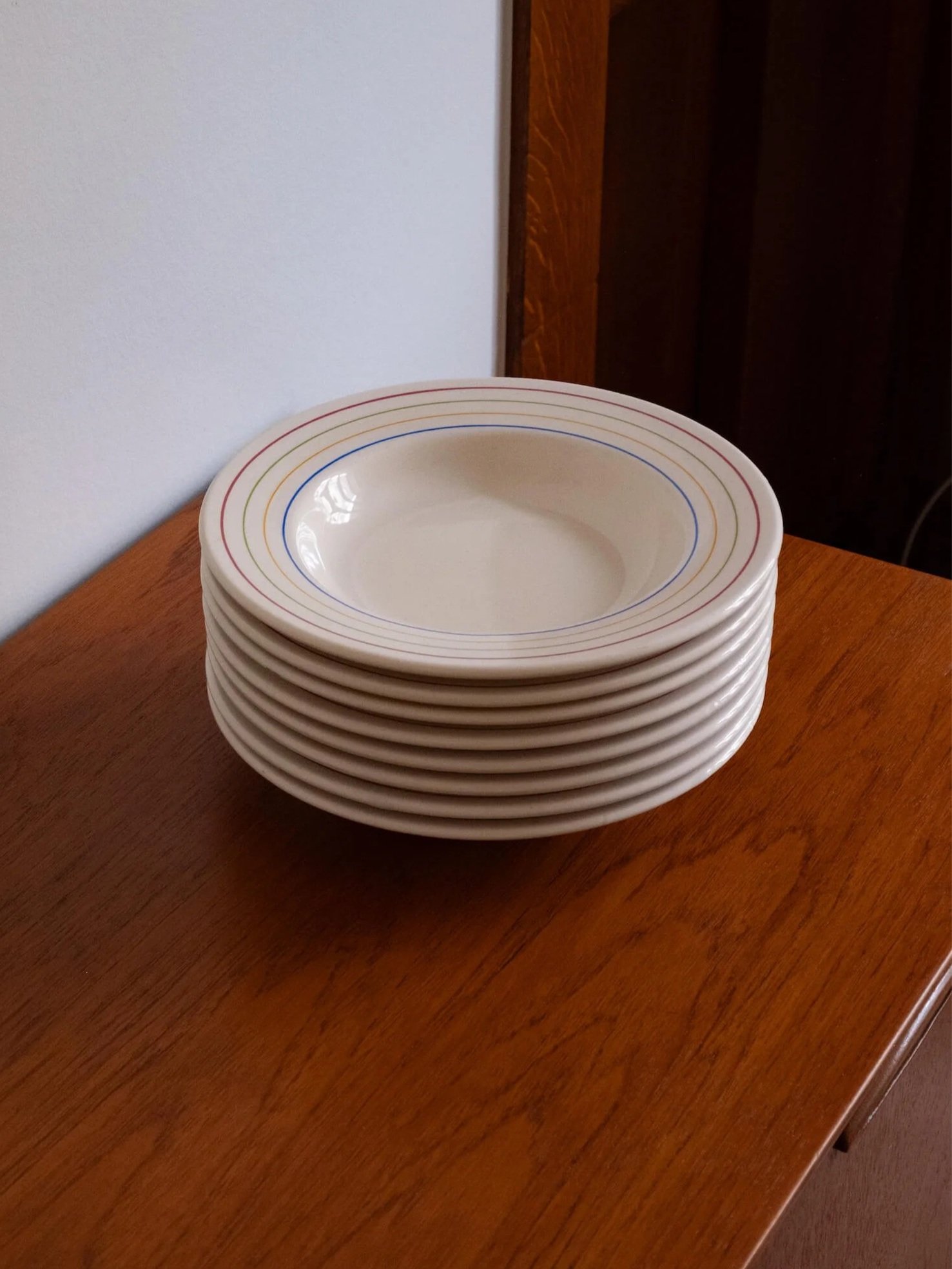 la pile de 8 assiettes creuses vintage avec liseré de plusieurs couleurs en parfait état