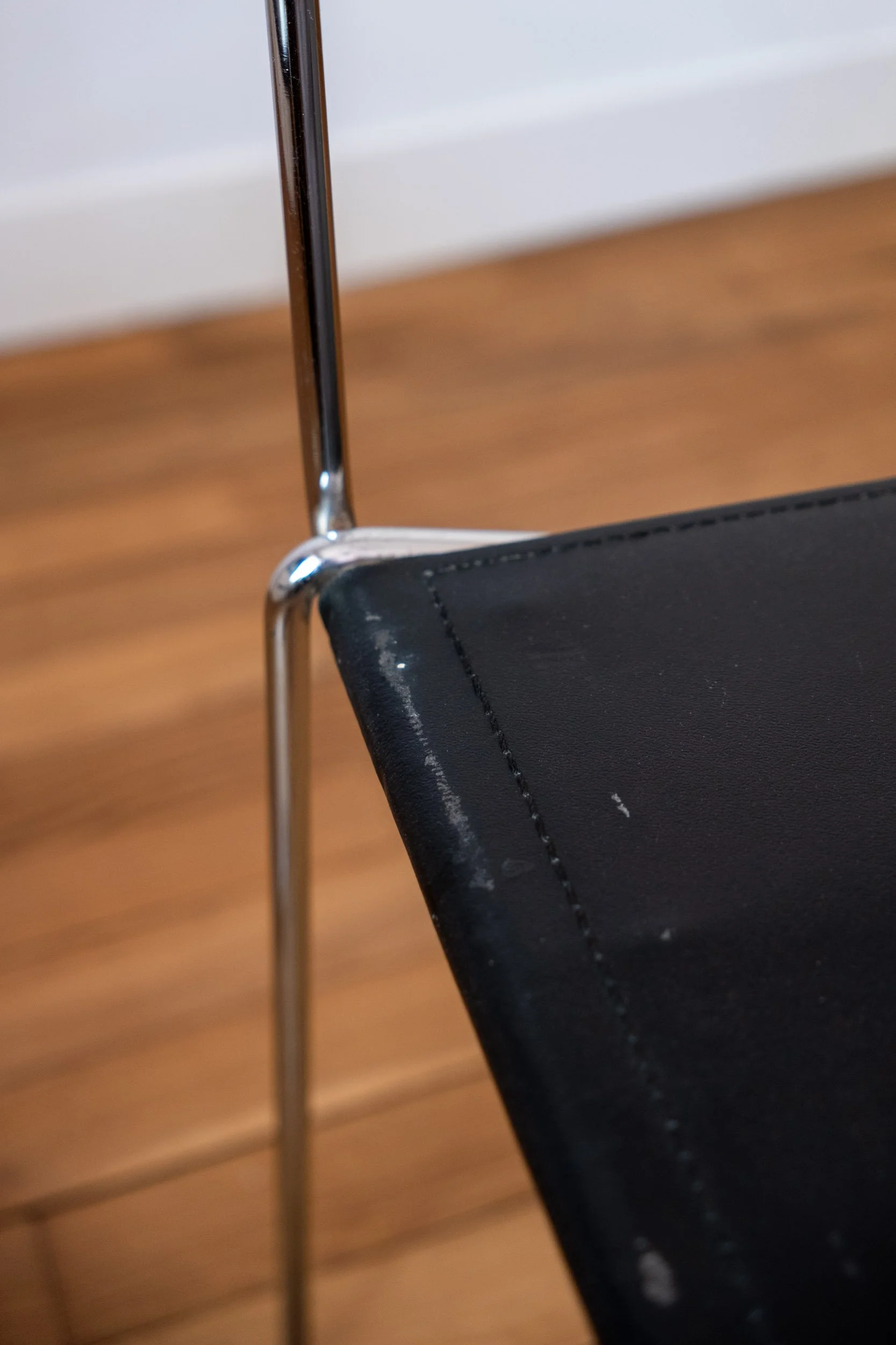 zoom sur une trace d'usure de la chaise en métal chromé et cuir noir italienne design