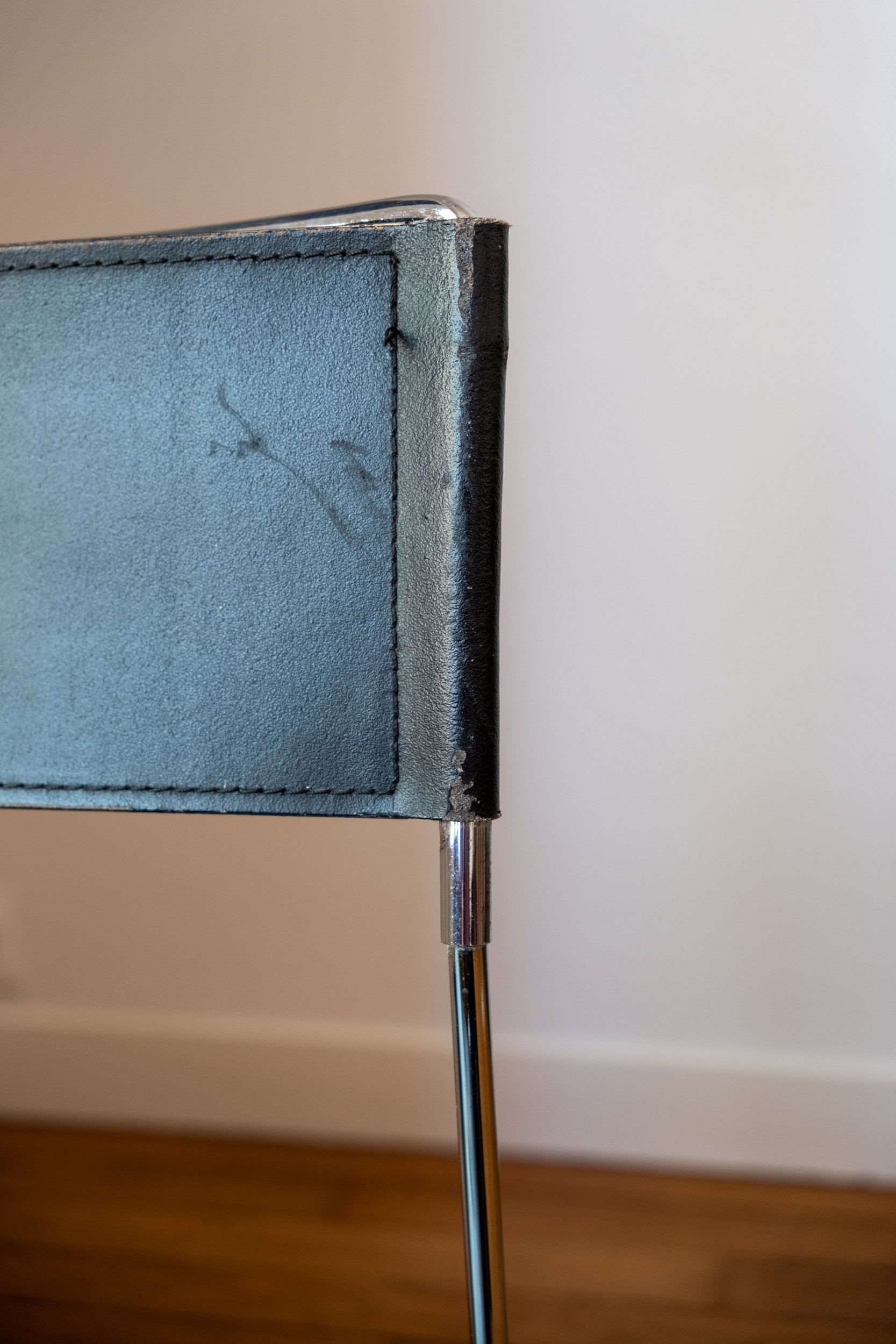 zoom sur une trace d'usure de la chaise en métal chromé et cuir noir italienne design