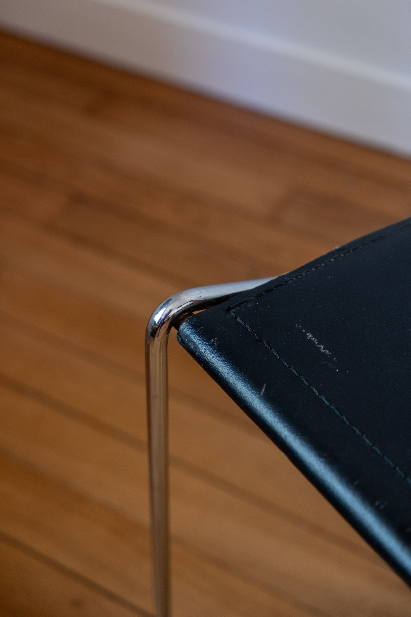 zoom sur une trace d'usure de la chaise en métal chromé et cuir noir italienne design