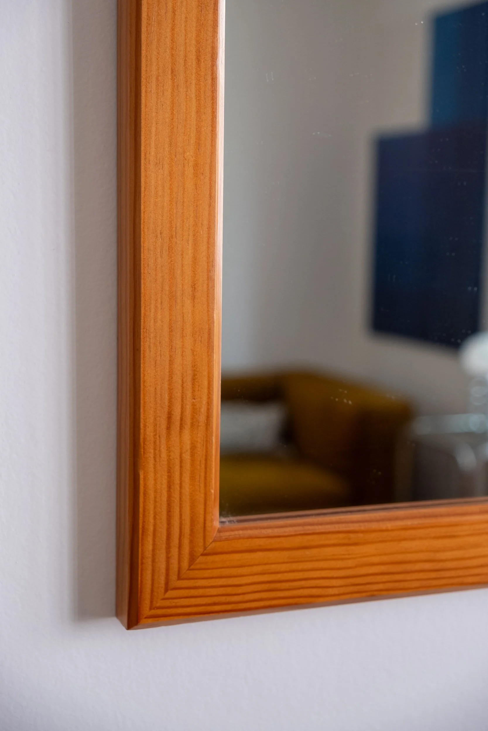 zoom sur la base en bois de ce miroir vintage des années 70