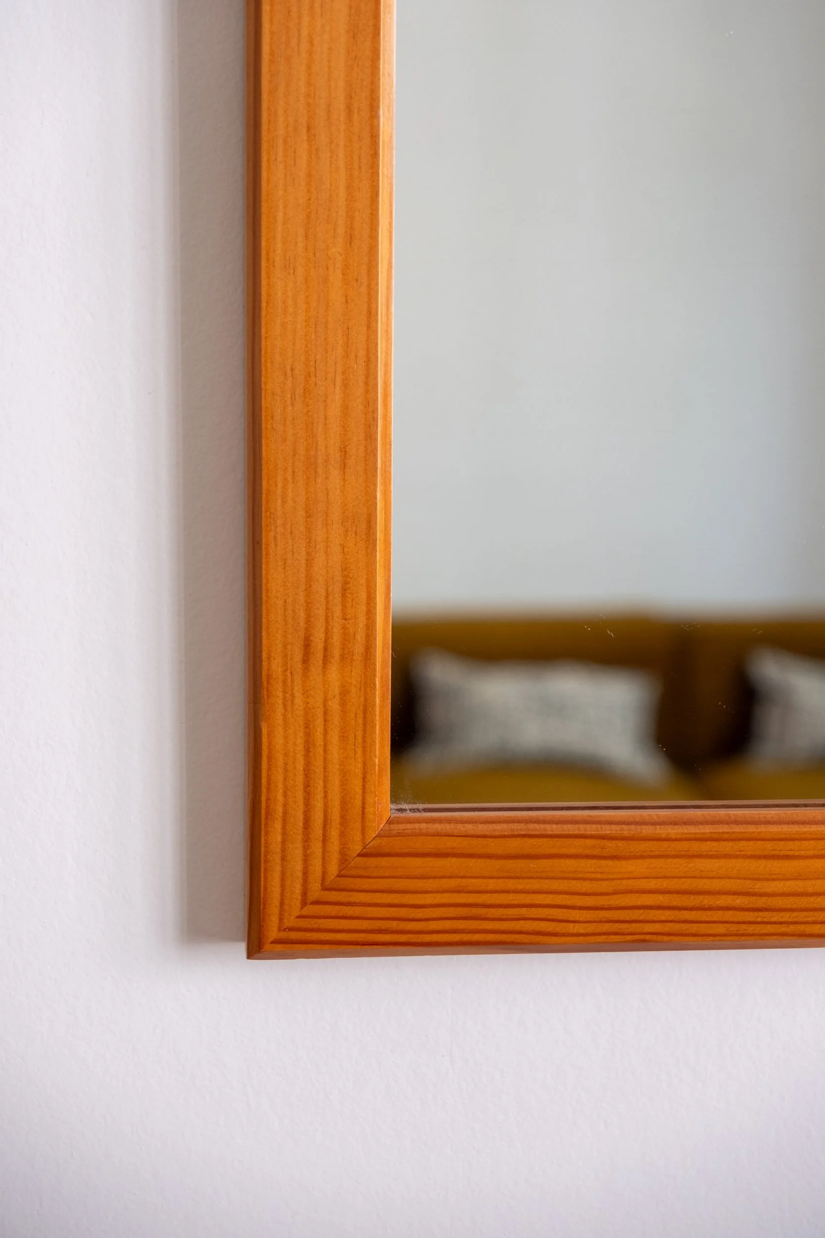 zoom sur la base droite en bois de ce miroir vintage des années 70
