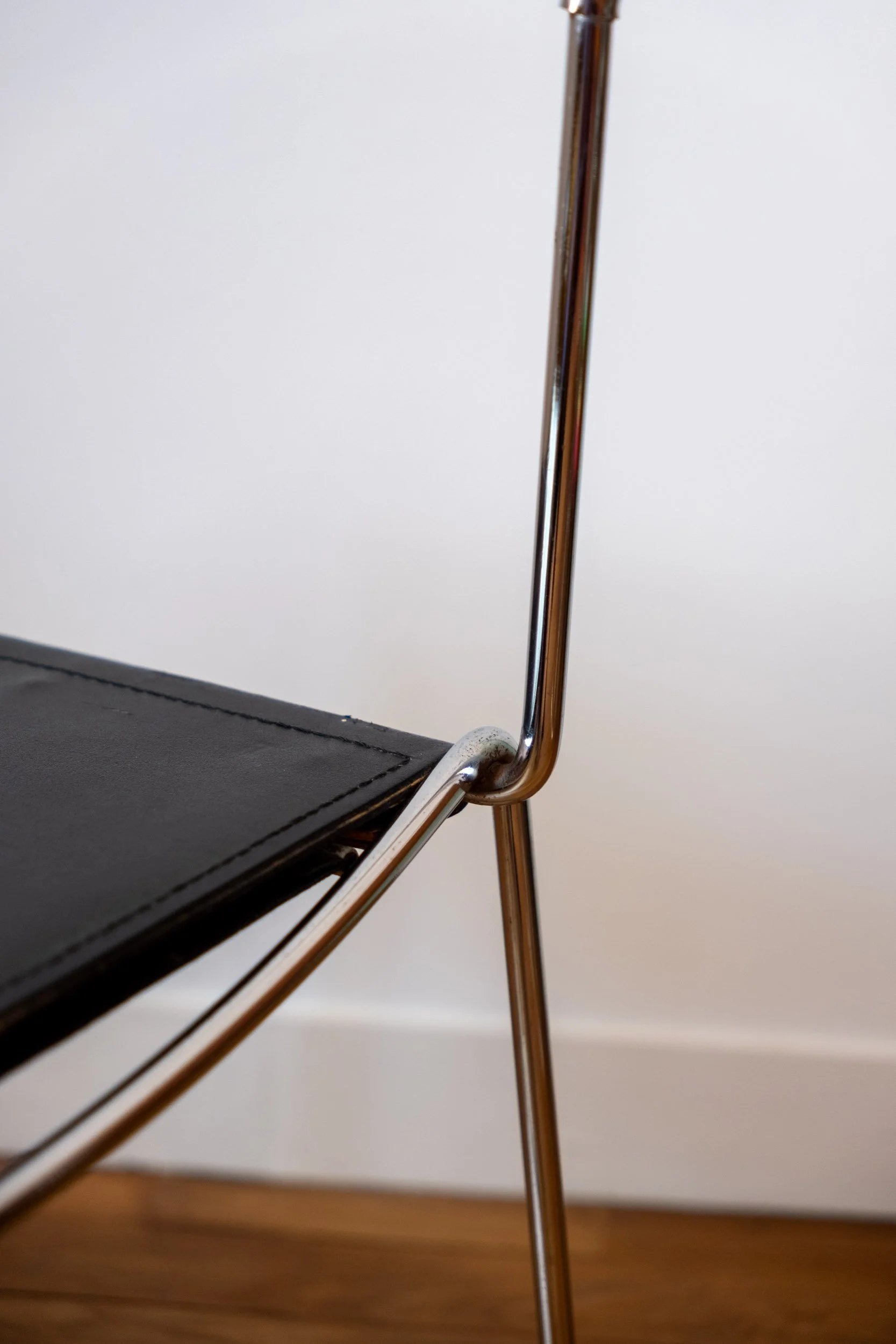 détail de la chaise en métal chromé et cuir noir italienne design
