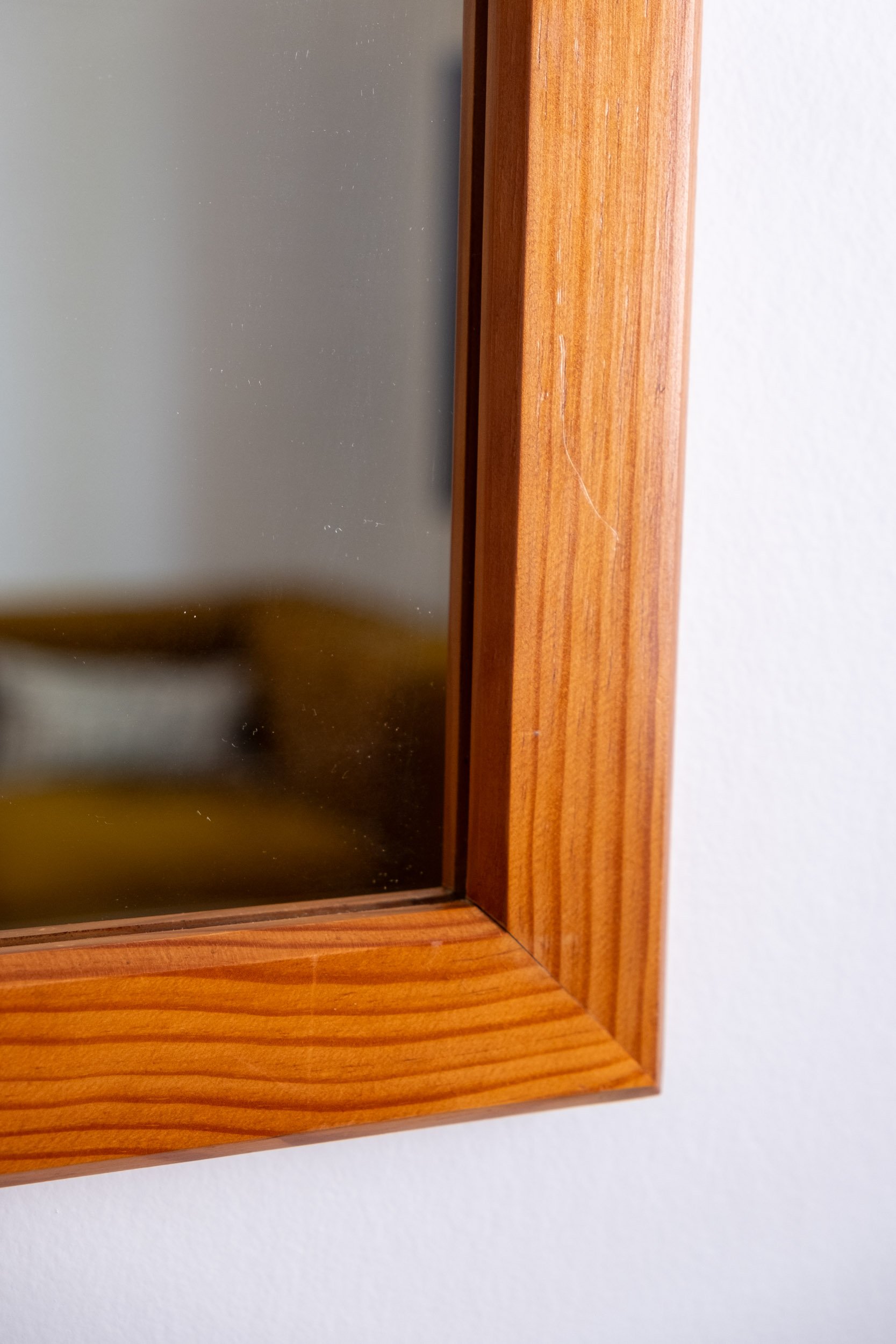 zoom sur la base droite en bois de ce miroir vintage des années 70