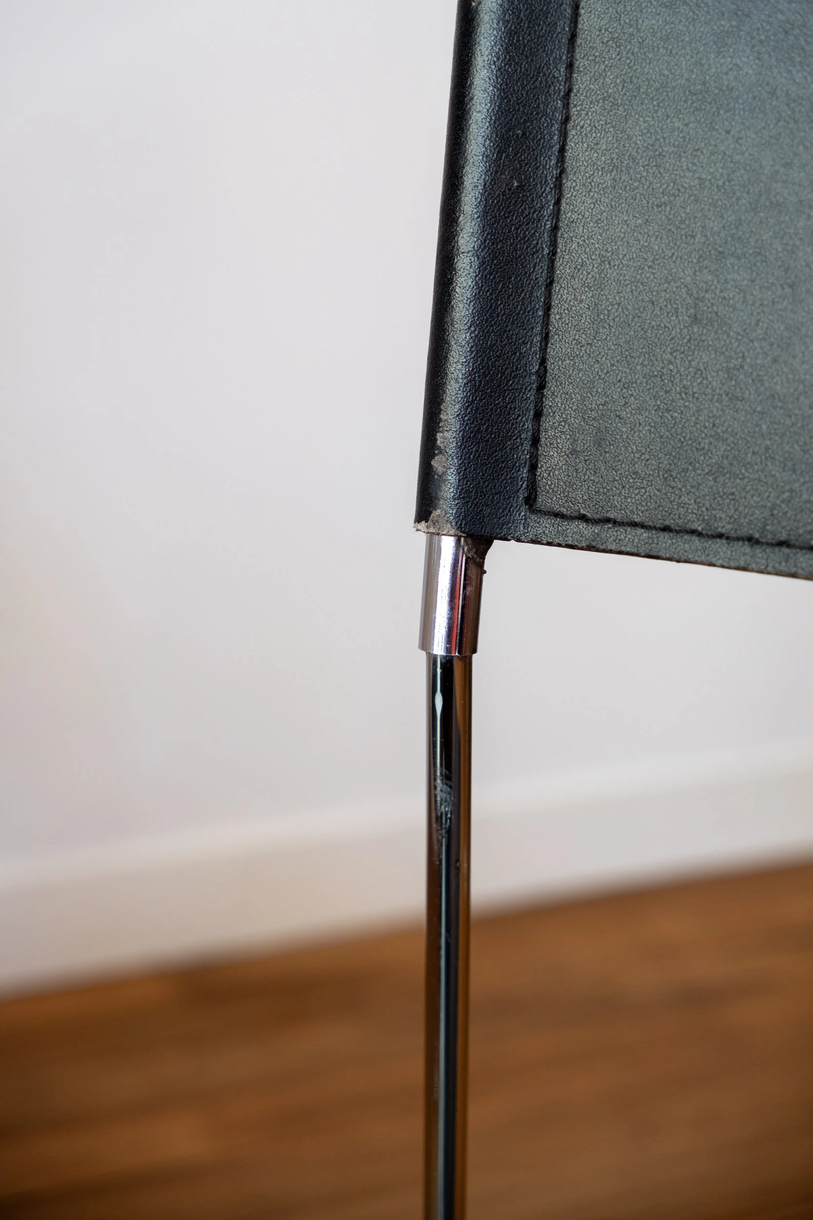 zoom sur une trace d'usure de la chaise en métal chromé et cuir noir italienne design