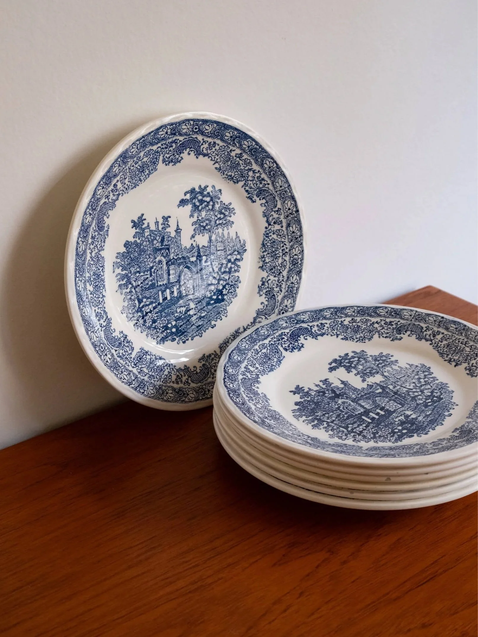pile d'assiettes plates vintage et vue sur une assiette de face pour montrer leur décor château bleu