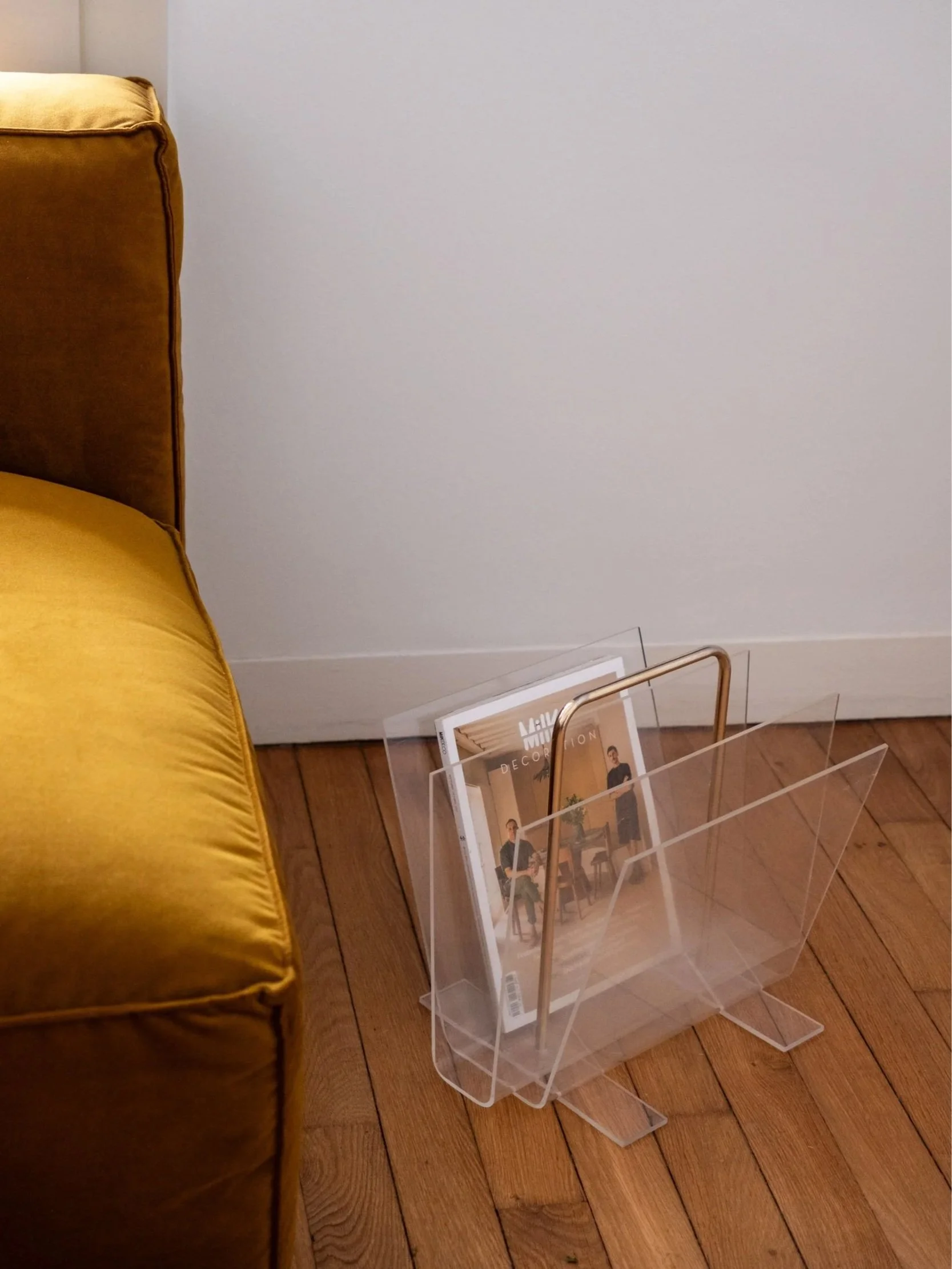 le porte-revues vintage mis en situation au pied d'un canapé