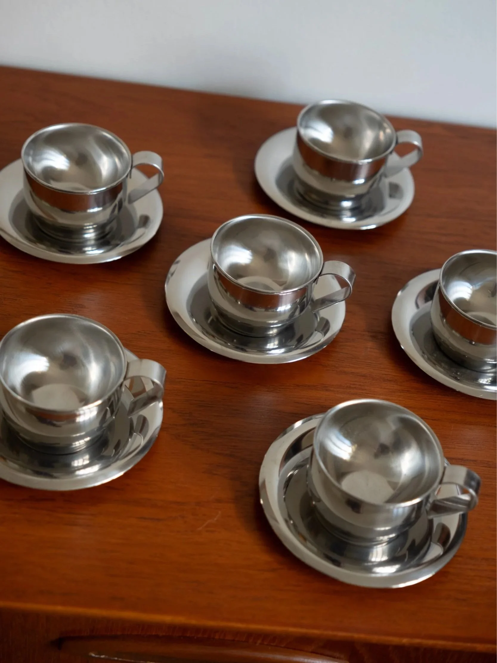 les tasses à café en inox avec leurs sous-tasses vintage présentées côte à côte