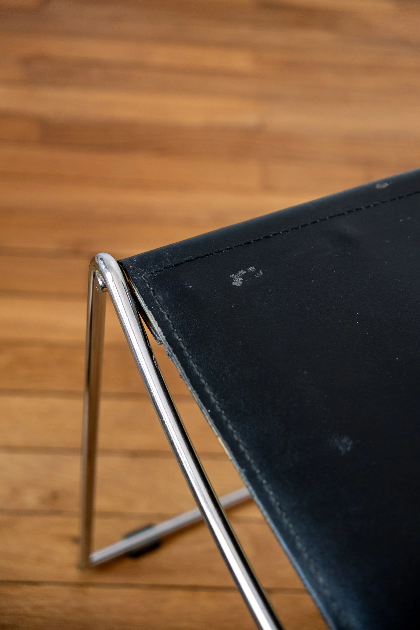 zoom sur une trace d'usure de la chaise en métal chromé et cuir noir italienne design