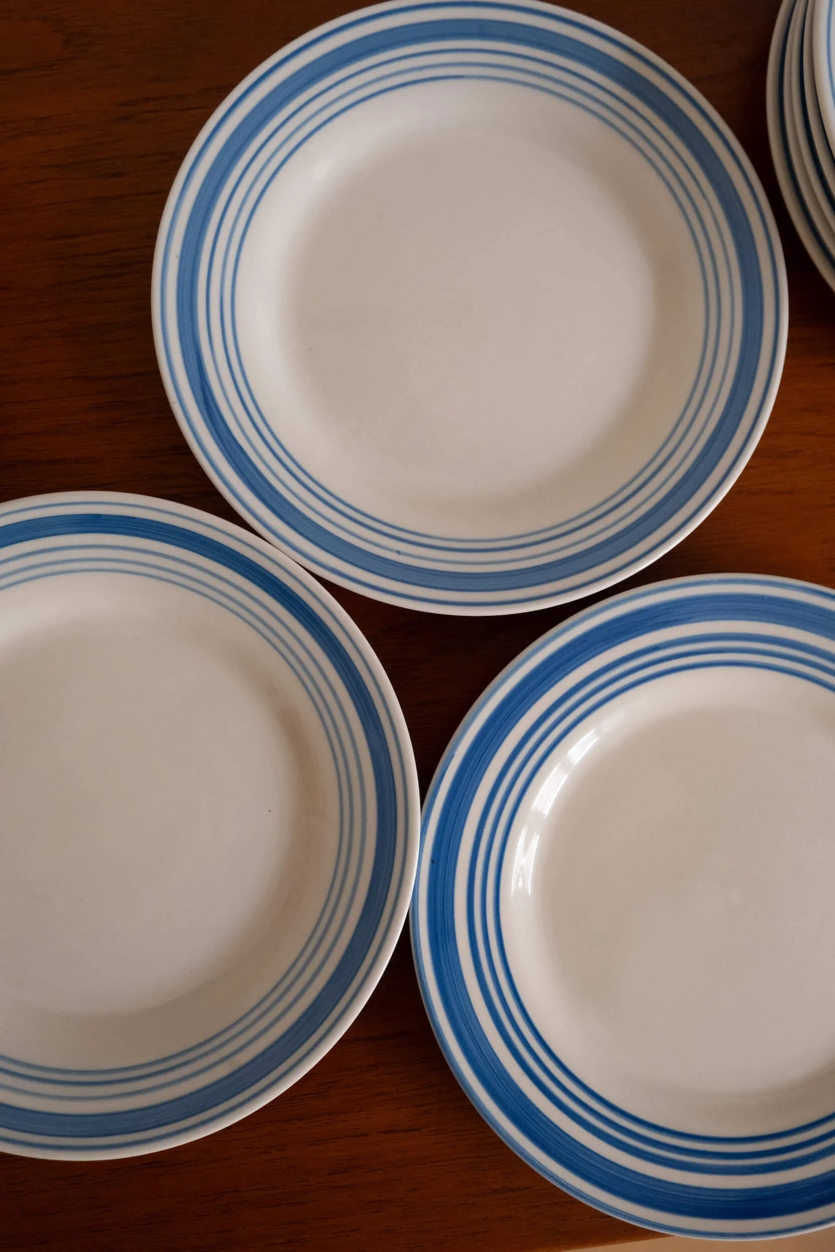 vue de haut sur ces 8 assiettes à dessert vintage avec des rayures bleues en parfait état