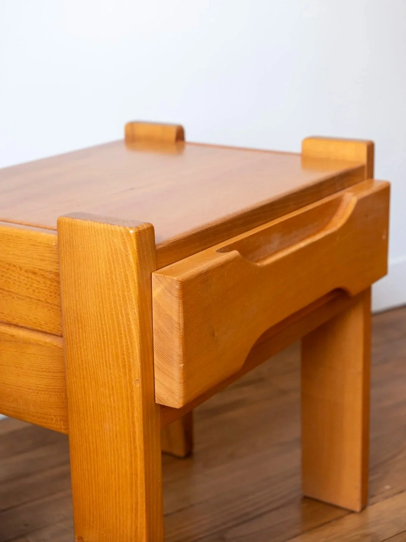 zoom sur la table de nuit en orme massif vintage au design brutaliste et minimaliste