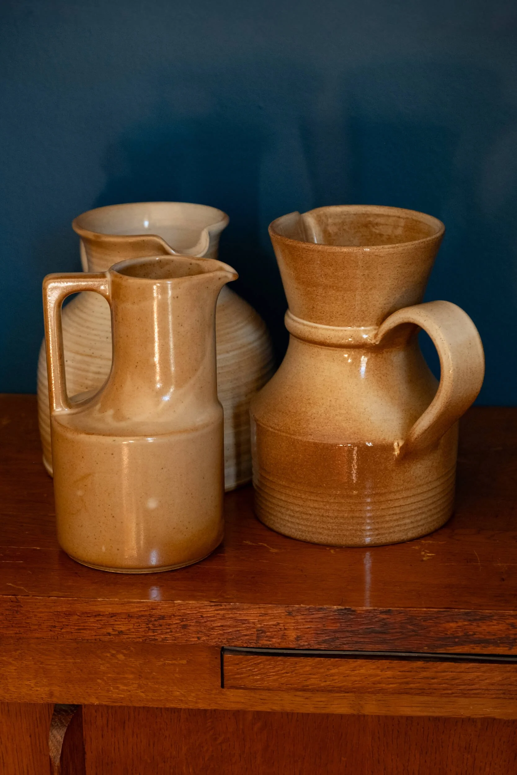 le pichet carafe en grès artisanal au milieu d'autres pichets en grès