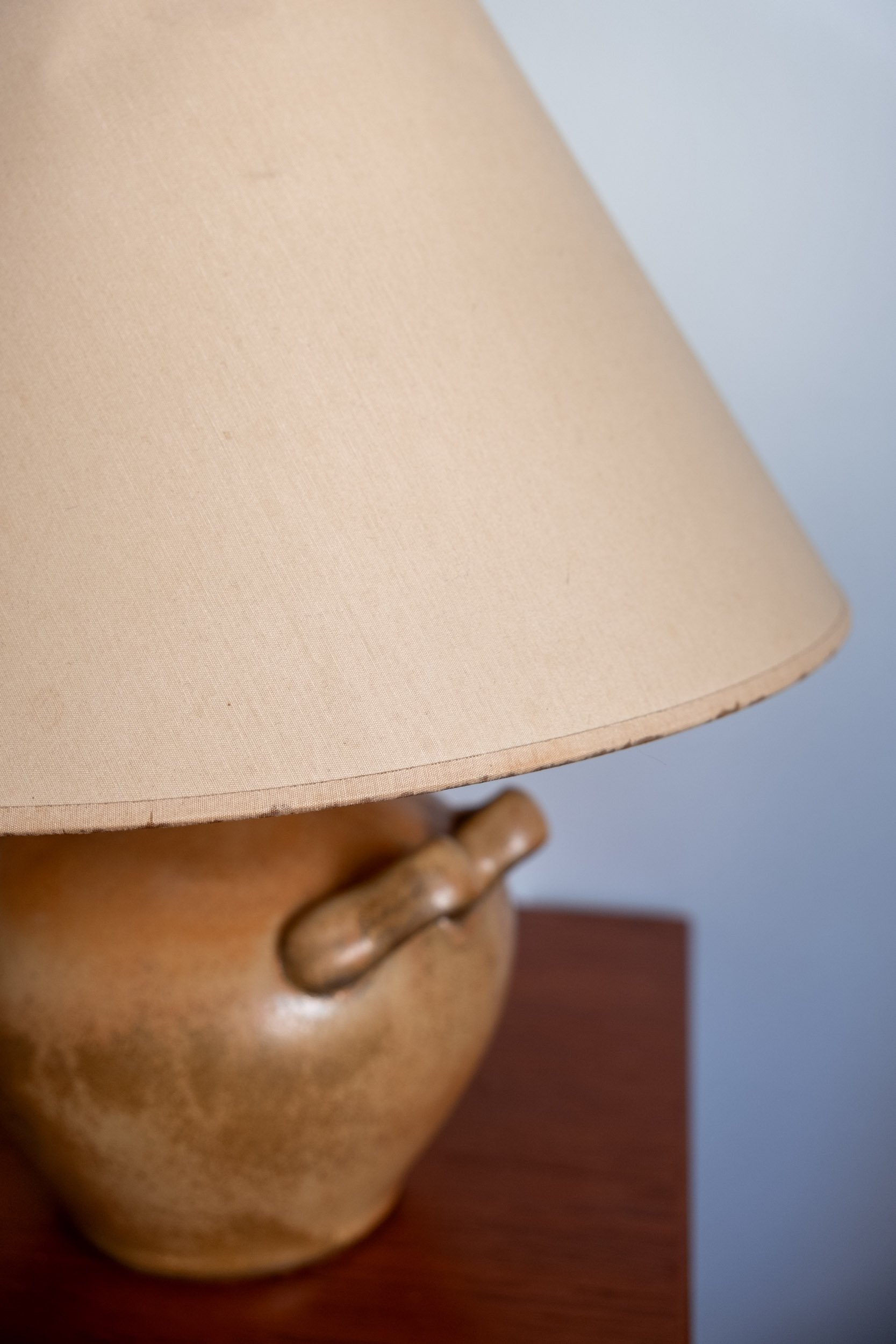 zoom sur les légères traces d'usure de l'abat-jour de cette lampe vintage au pied en grès