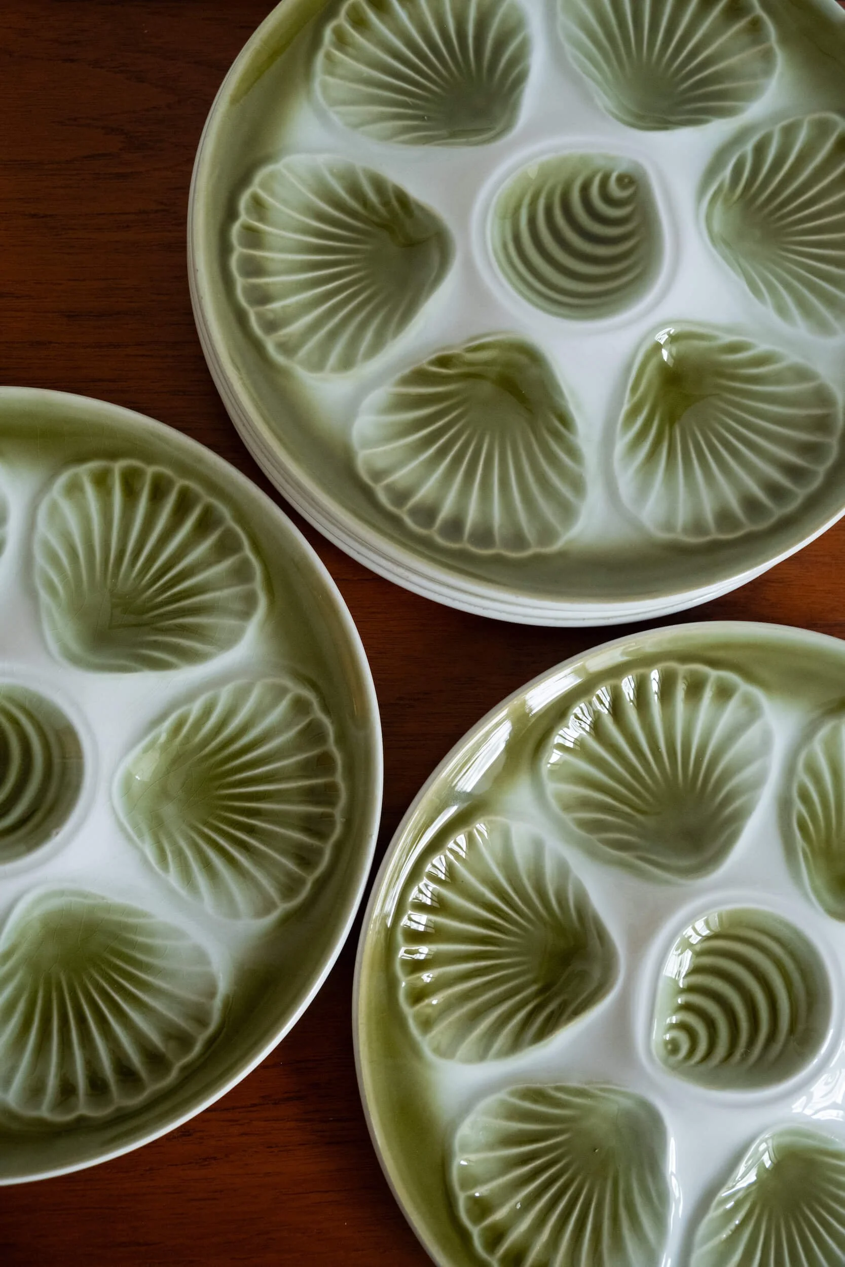 vue de haut sur les assiettes à huîtres vintage décor de couleur verte Grand Feu des années 70