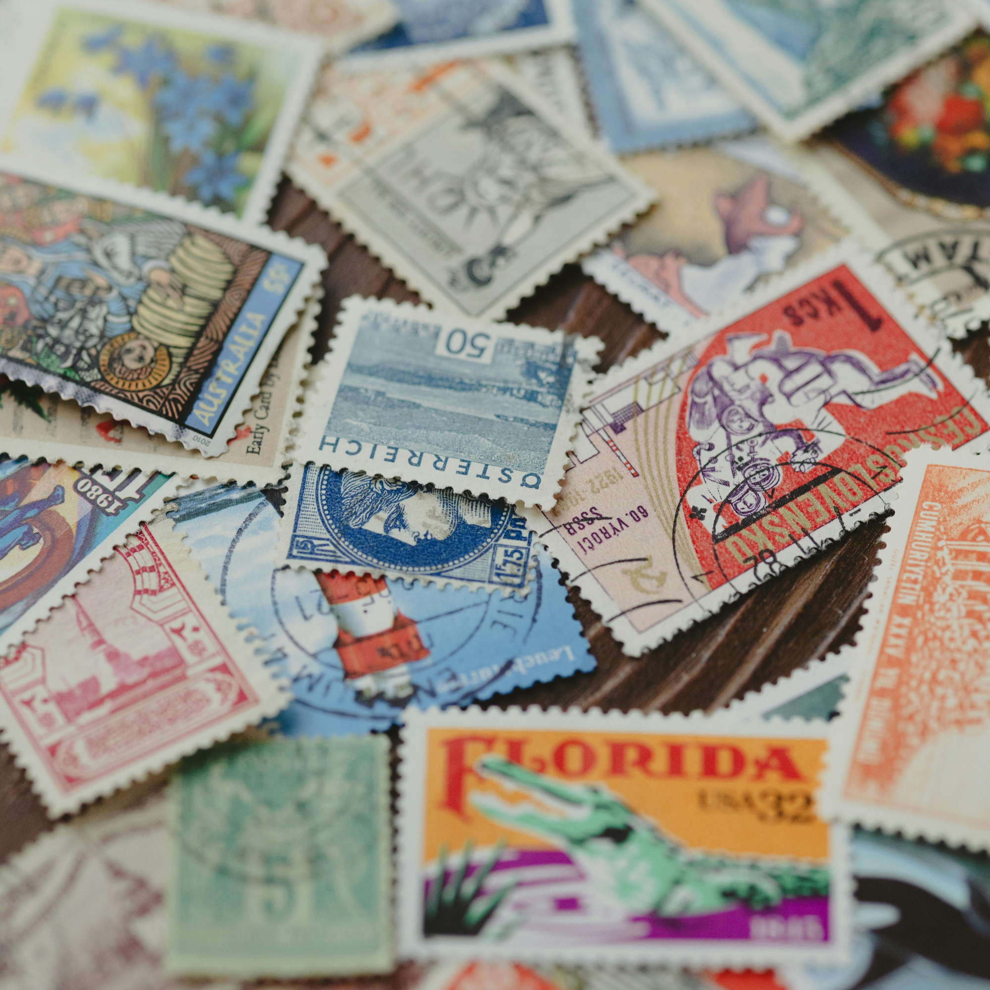 A pile of colorful vintage postage stamps with various designs and denominations.
