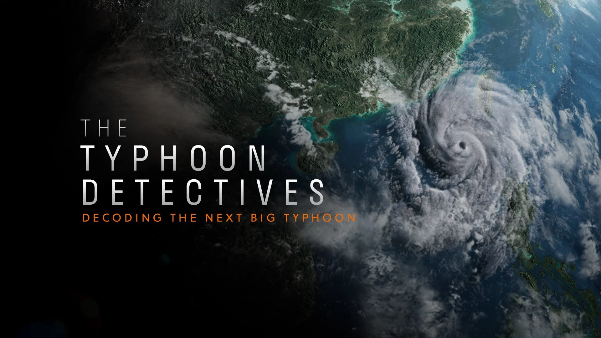 Satellite image of a typhoon approaching land, with the storm's eye visible over the ocean near a green, forested coastline.