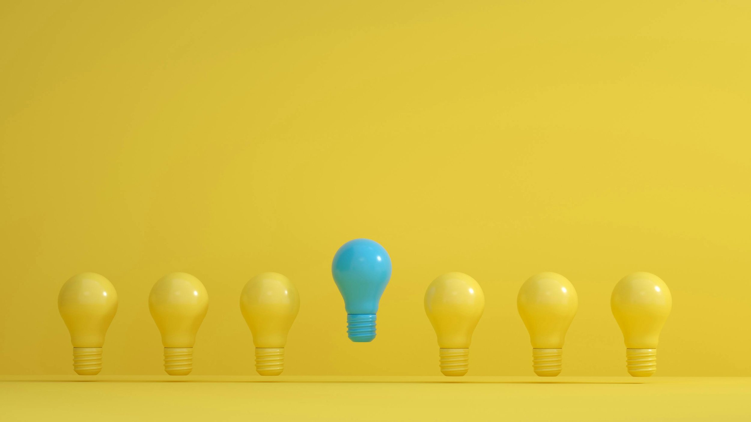 A row of six yellow light bulbs with a blue light bulb in the center, all against a yellow background.