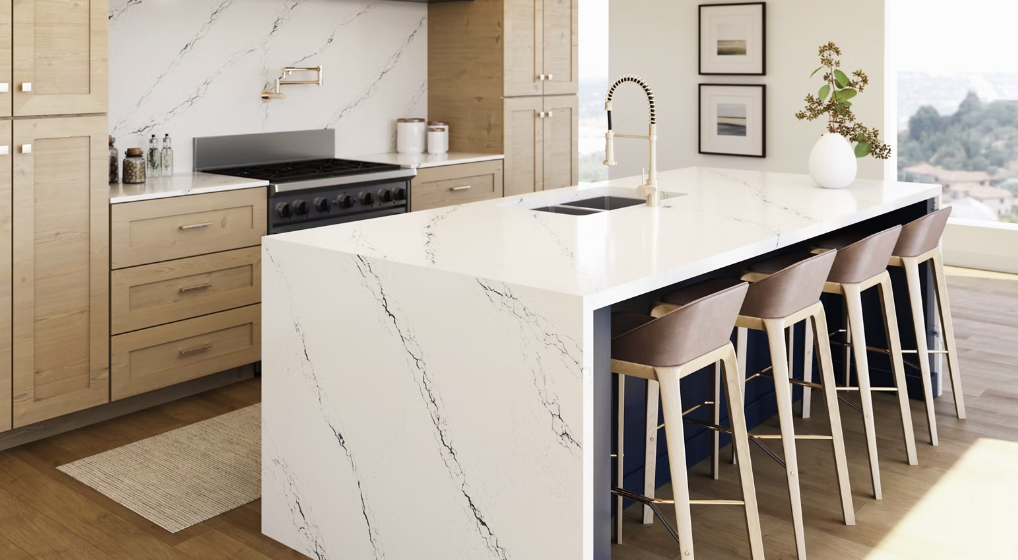 Modern kitchen with white marble island, wooden cabinets, black stove, and bar stools.
