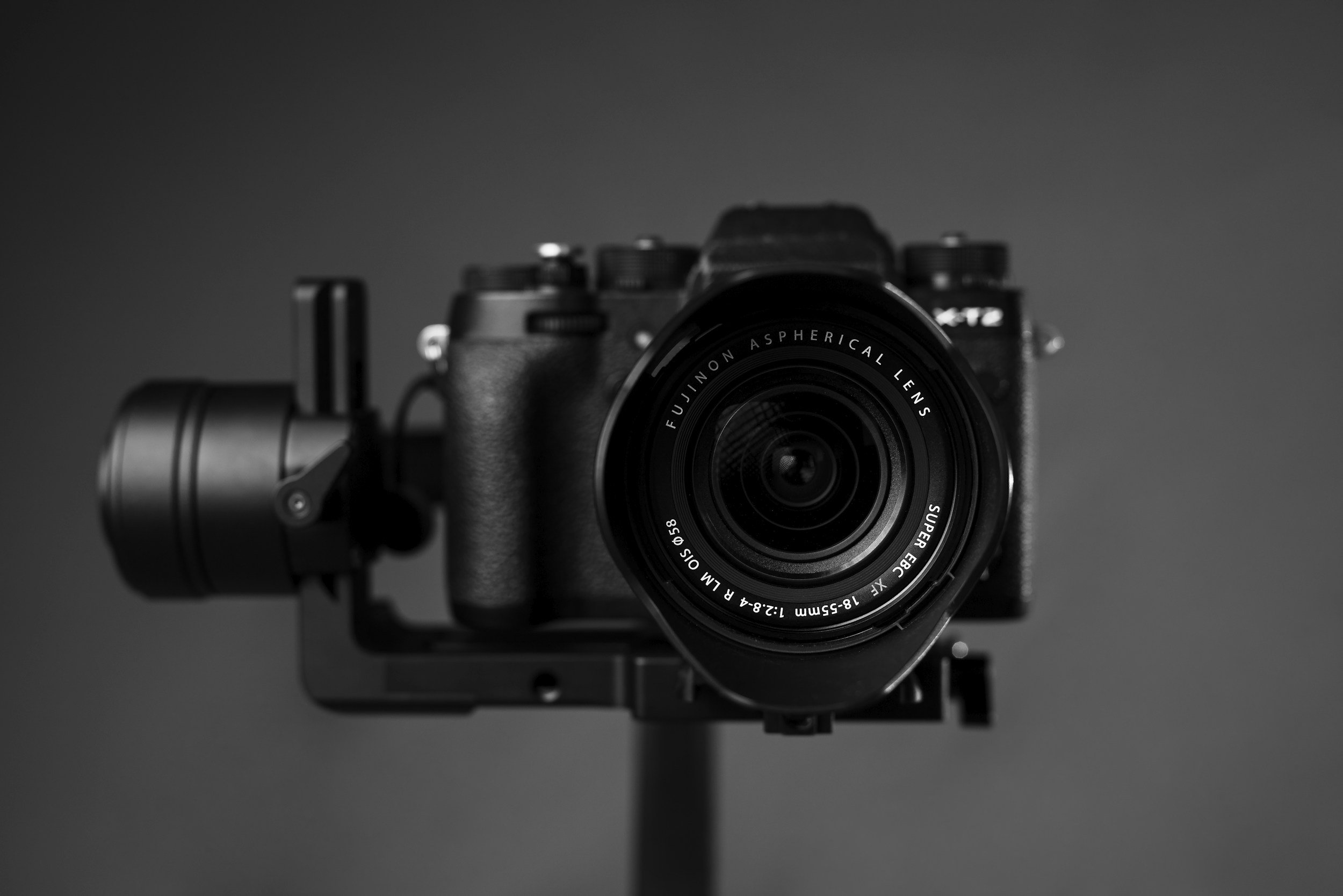 A black camera with a mounted lens, centered in the image against a dark background.