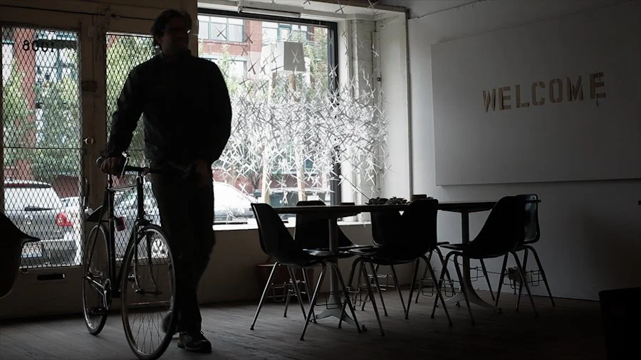 Silhouette of person walking into their design studio with their bike